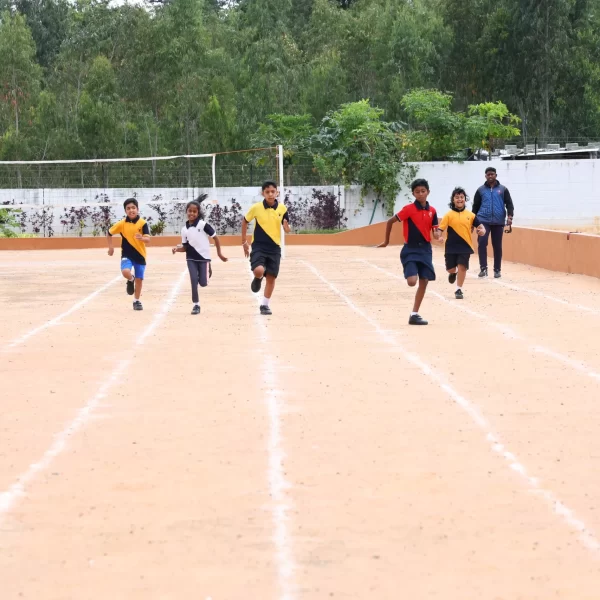 Children running on an outdoor track during a race.