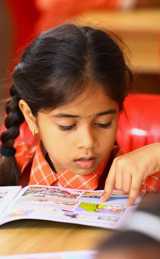 A young student reading a book in class.